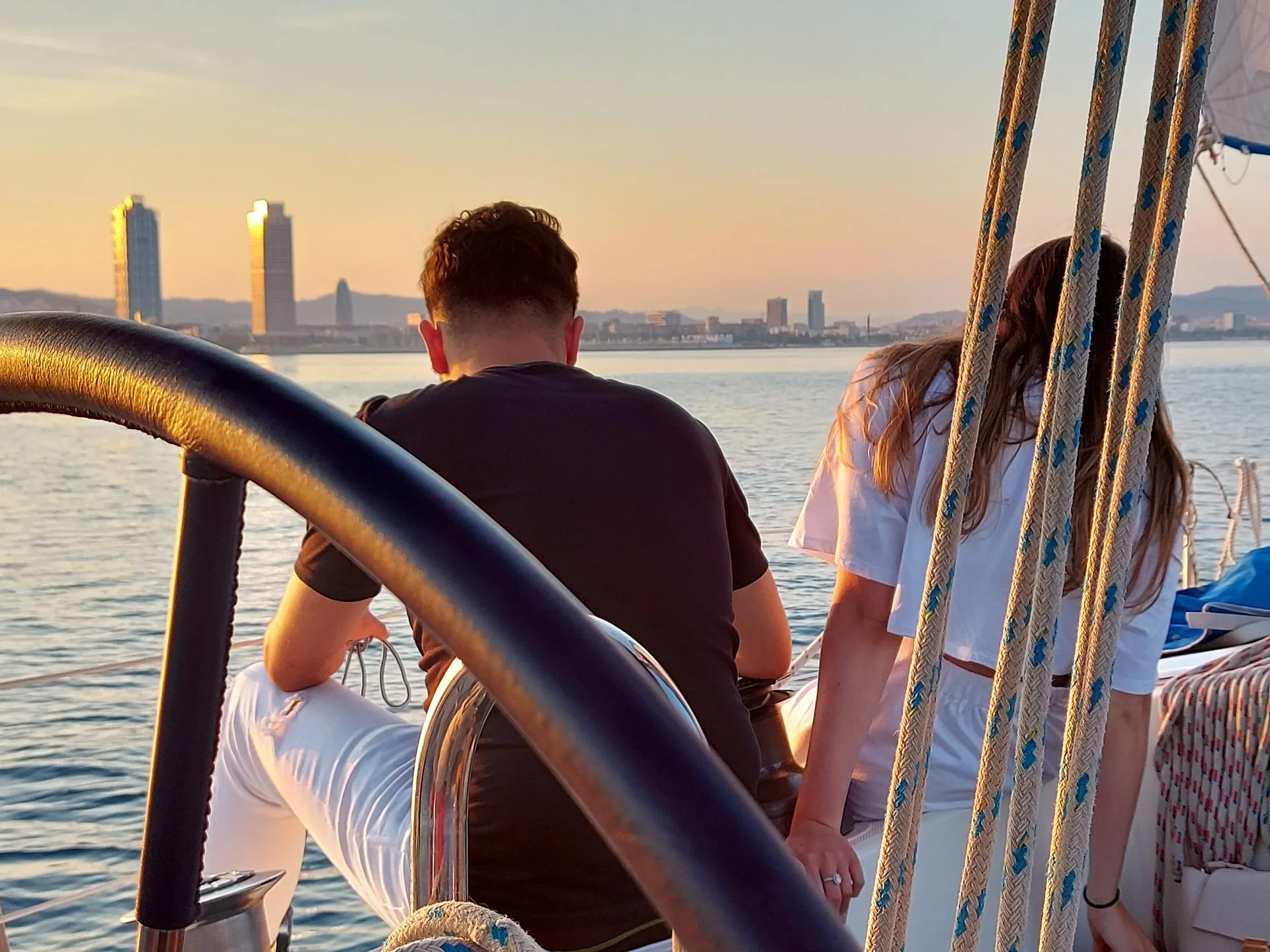 Passeio de veleiro em Barcelona ao pôr do sol — pessoas a bordo com a cidade ao fundo