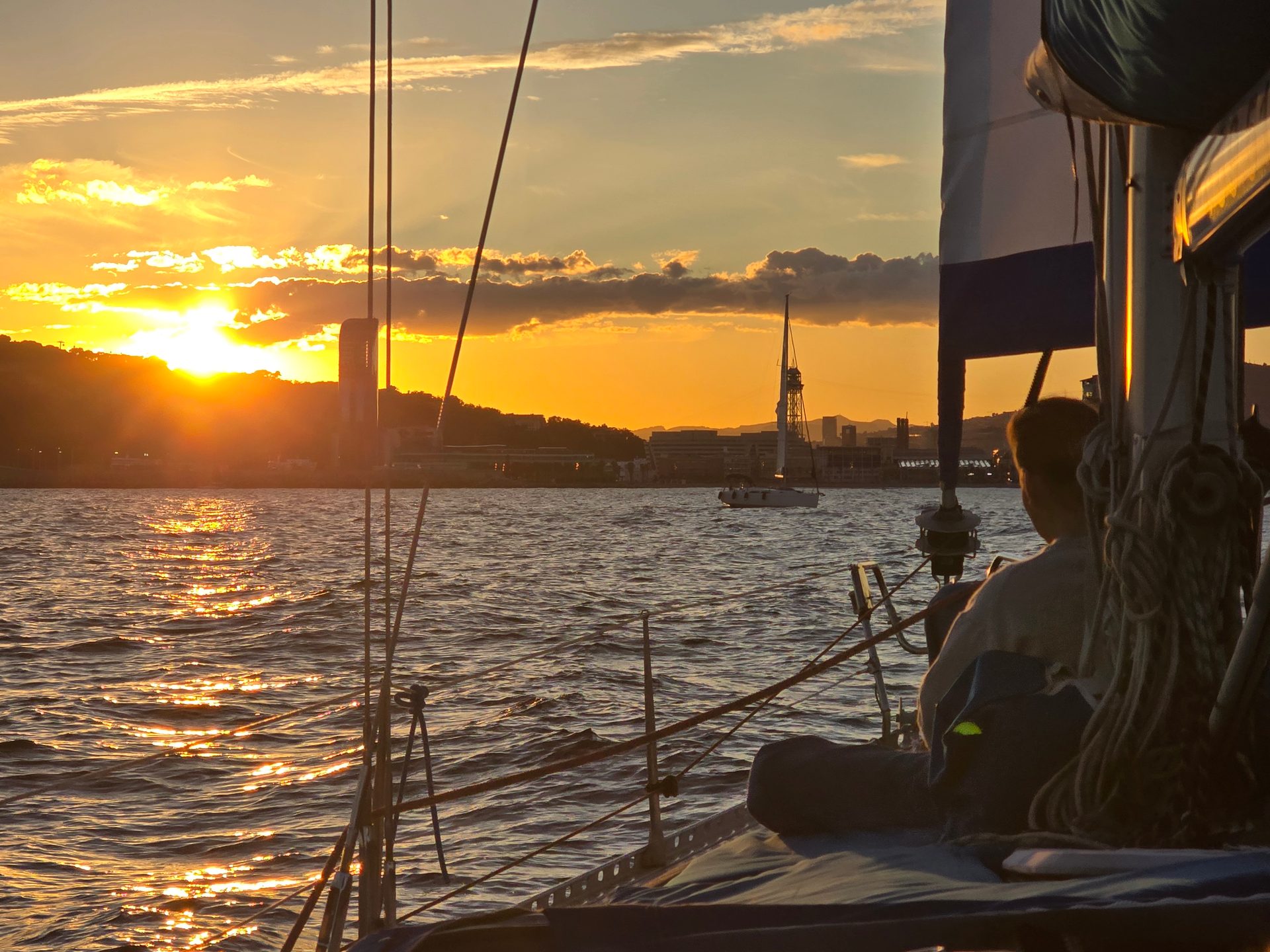 Atardecer dorado desde el velero con el skyline de Barcelona al fondo