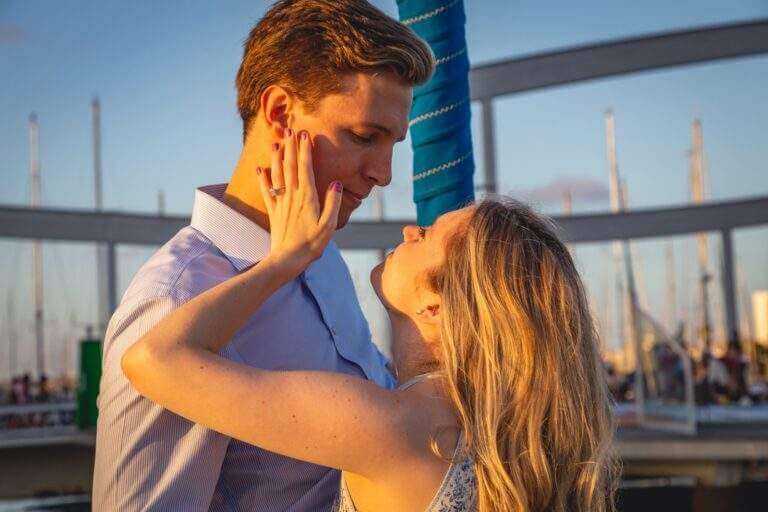 Velero navegando al atardecer frente a Barcelona — experiencia pernocta romántica