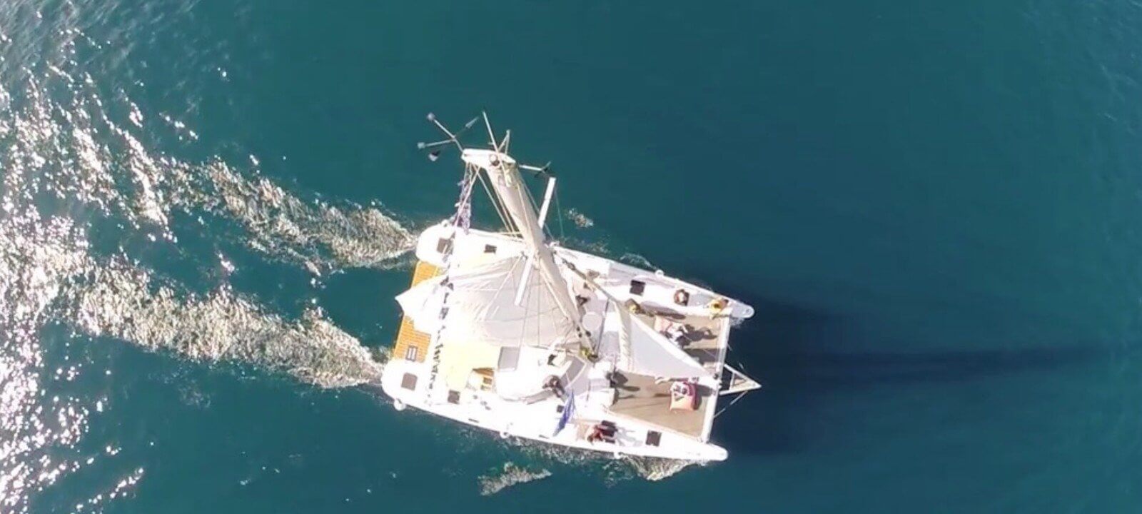 Premium-Katamaran segelt durch Barcelona mit Skyline im Hintergrund