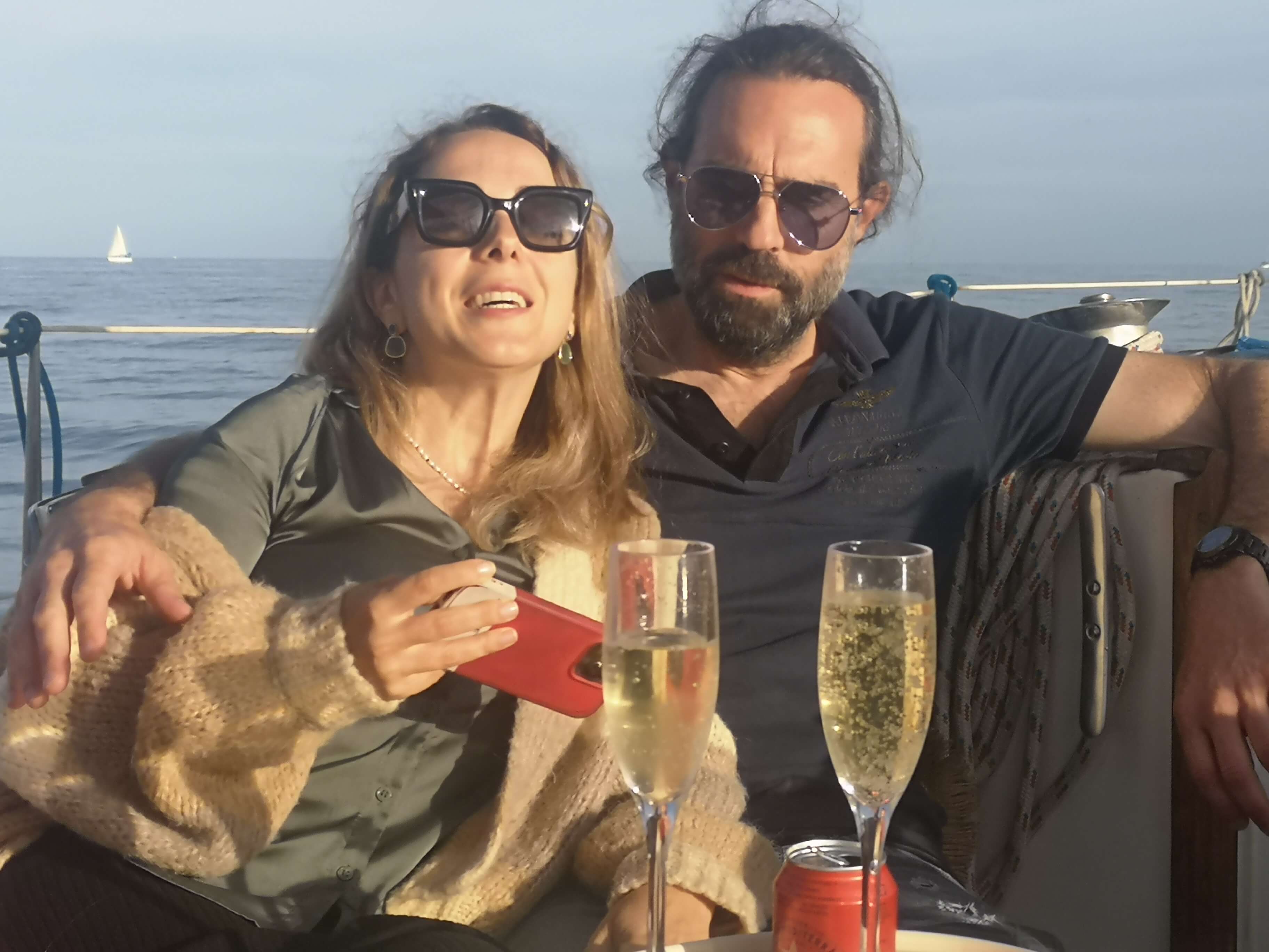 Brindis con cava a bordo del velero durante la puesta de sol en Barcelona