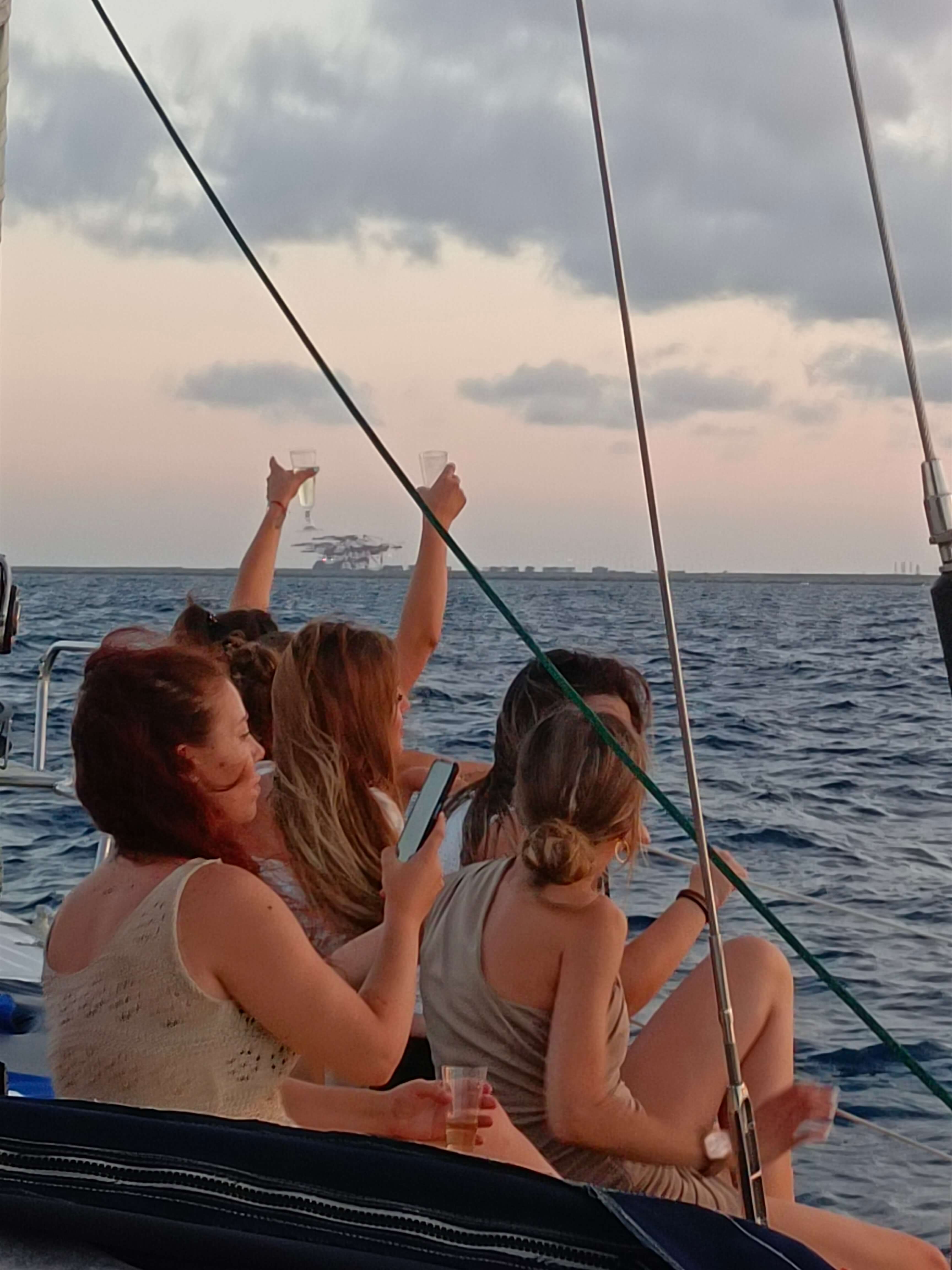 Amigas brindando en velero al atardecer — cumpleaños Barcelona