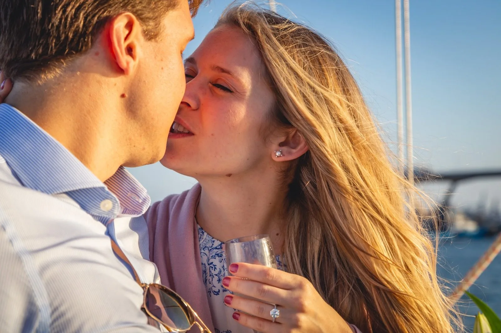Pareja abrazada al atardecer en la cubierta del velero privado