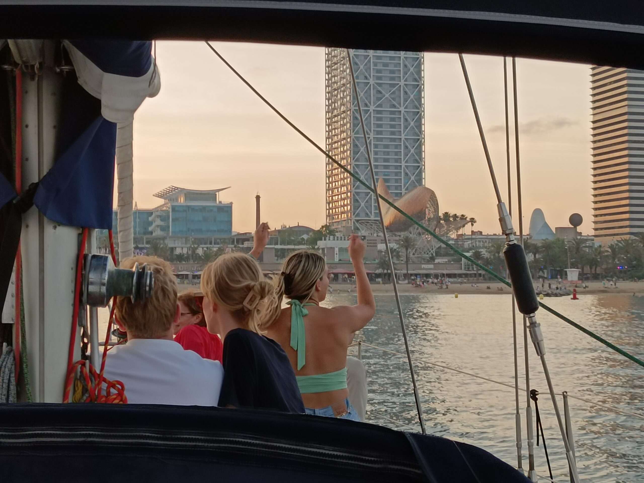 Pasajeros disfrutando del tour en velero 2 horas por Barcelona